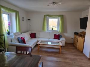 a living room with a white couch and a coffee table at Binder's Ferienhaus zur Altmühl in Leutershausen