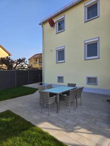a patio with a table and chairs in front of a house at Binder's Ferienhaus zur Altmühl in Leutershausen