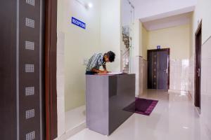 a person sitting on a counter in a room at Super Hotel O Viraj Deluxe Narela in Delhi