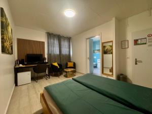 a bedroom with a bed and a desk with a computer at Auberge Pour Tous in Vallorbe