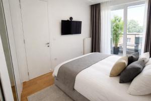 a bedroom with a bed with a television on the wall at Extra Apartman Palata in Banja Luka