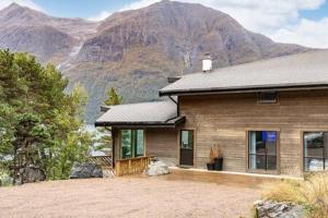 a house with a mountain in the background at Torvika Hus in Isfjorden
