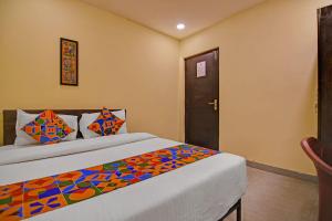 a bedroom with two beds and a door at FabHotel The Crown Aura in kolkata
