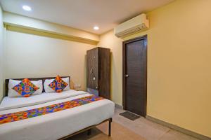 a bedroom with a bed and a closet and a door at FabHotel The Crown Aura in kolkata +21 photos
