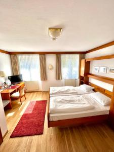 a bedroom with a large bed and a desk at Hotel Krone Neuenburg in Neuenburg am Rhein