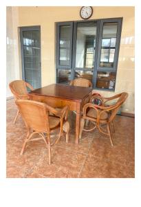 a wooden table with chairs and a clock on the wall at Xiannv Mountain House in Chongming +6 photos