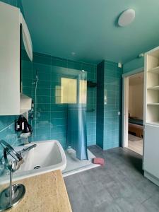 a bathroom with blue tiled walls and a bath tub at Auberge Pour Tous in Vallorbe +123 photos