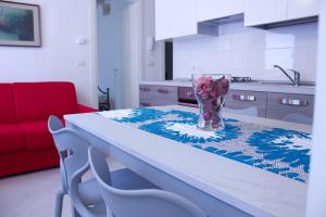 a kitchen with a table with a vase of flowers on it at Iris Chioggia in Chioggia