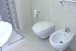 a white bathroom with a toilet and a sink at Iris Chioggia in Chioggia