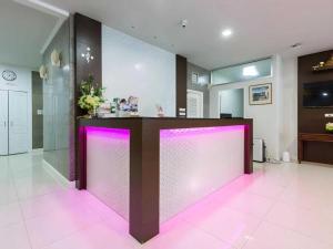 a lobby with a pink lighted counter in a room at Collection O The Step Sathorn in Bangkok