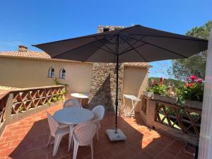 a patio with a table and chairs and an umbrella at Chambre bleue Villalormarin in Saint-Tropez