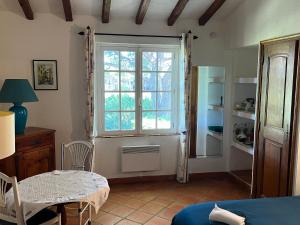 a room with a window and a table and a kitchen at Chambre bleue Villalormarin in Saint-Tropez