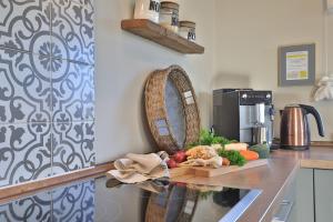 a kitchen counter with a cutting board with vegetables on it at Das Reethaus in Groß Schwansee