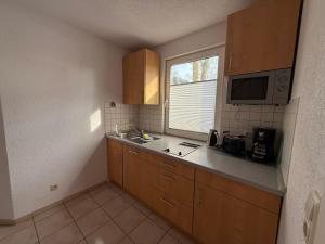 a small kitchen with a sink and a microwave at Wittower Heide 40-1 in Glowe