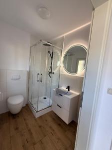 a bathroom with a shower and a toilet and a sink at Wittower Heide 40-1 in Glowe