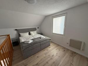 a small bedroom with a bed and a window at Wittower Heide 40-1 in Glowe +24 photos