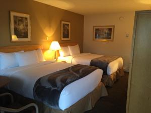 a hotel room with two beds and a lamp at Eastglen Inn in Edmonton