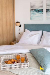 a tray of food and two drinks on a bed at Sun-Splashed Top-Floor APT with Seaview and Jacuzzi! in Vari