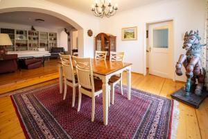 a dining room with a table and chairs on a rug at Villa Marga Ferienwohnung Jenner in Schönau am Königssee