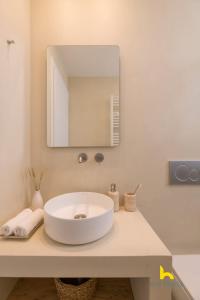 a bathroom with a white sink and a mirror at Sun-Splashed Top-Floor APT with Seaview and Jacuzzi! in Vari +19 photos