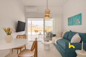 a living room with a blue couch and a table at Sun-Splashed Top-Floor APT with Seaview and Jacuzzi! in Vari