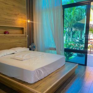 a bedroom with a bed and a large window at Bird House Ecolodge Nghệ An in Hữu Biêt