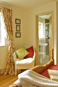 a living room with a chair and a bathroom at Llety Farm in St. Davids