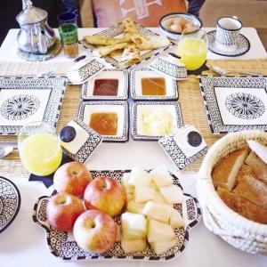 a table with apples and other food on it at Zahra Luxury Desert Camp in Merzouga +37 photos