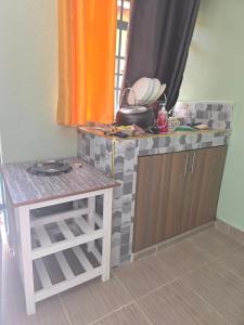 a kitchen with a counter and a table and a counter top at Ibus Nawi homes in Lodwar +2 photos
