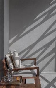 a wooden chair with shadows on a wall at Kempinski Hotel Muscat in Muscat