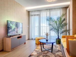 a living room with a television and a table at Eurovea Tower Apartment 27th floor, Luxury bed VISPRING Baronet Superb in Ovsište