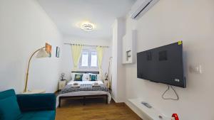 a bedroom with a bed and a tv on a wall at Cascais Garden House in Cascais