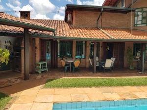 a house with a patio with a table and chairs at Casa Com Piscina in Campinas