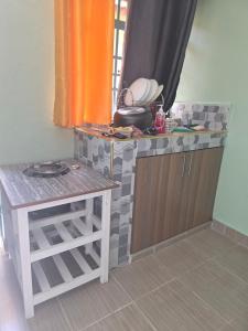 a small kitchen with a counter and a table at Ibus Nawi homes in Lodwar
