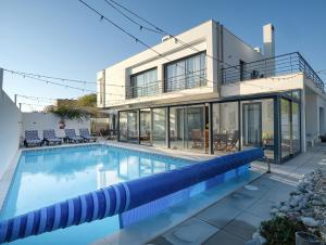 a large swimming pool in front of a house at Maresia Villa Mar in Nazaré +54 photos