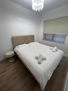 a bedroom with a white bed with towels on it at Gosen Grand Residence in Sângeorz-Băi