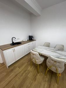 a kitchen with a table and chairs in a room at Gosen Grand Residence in Sângeorz-Băi
