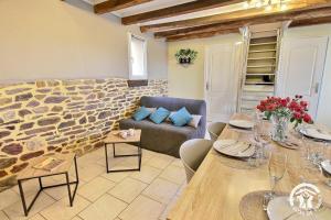 a living room with a couch and a stone wall at Du bonheur à la campagne in Mauron +19 photos