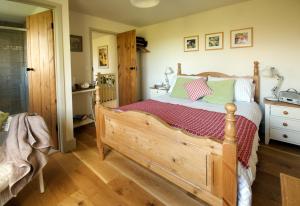 1 dormitorio con cama de madera y suelo de madera en Llety Farm, en St. Davids