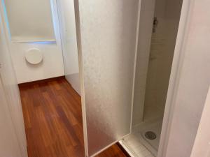a shower stall in a bathroom with a wooden floor at Appartamenti Ariston - Centro Giulianova in Giulianova