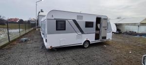 a white trailer parked next to a fence at Great Polonia Ustka in Ustka