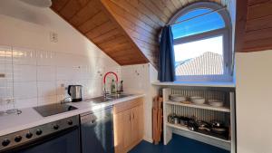 a small kitchen with a sink and a window at Mar Dolomiti Suite by Ca-Sa Check in San Michele