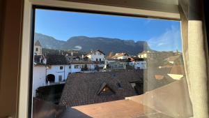 a view from a window of a town with mountains at Mar Dolomiti Suite by Ca-Sa Check in San Michele