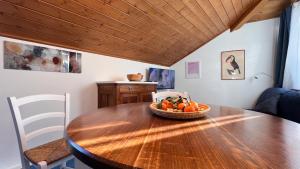 a dining room table with a bowl of oranges on it at Mar Dolomiti Suite by Ca-Sa Check in San Michele +10 photos