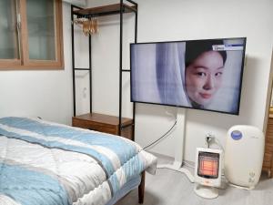 a bedroom with a bed and a flat screen tv at K Hubhouse - Taereung stn 5min walk#villa 4pax in Seoul