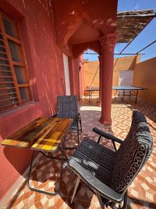a wooden table and chairs on a patio at Holly Hills Guesthouse Ras Al Jinz in Junayz al Janūbī