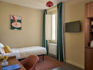 a room with a bed and a table and a tv at Numa Florence Rodo in Florence +33 photos