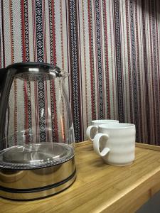 a glass blender and a cup on a wooden shelf at Holly Hills Guesthouse Ras Al Jinz in Junayz al Janūbī