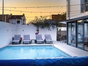 a group of chairs sitting next to a swimming pool at Maresia Villa Mar in Nazaré