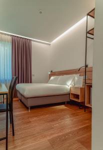 a bedroom with a bed and a desk and a window at GRANDI 32 Boutique Residence in Segrate